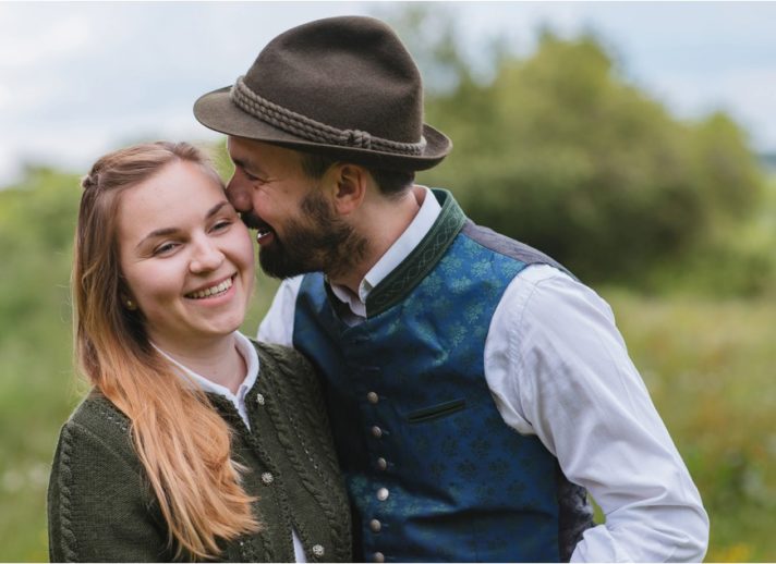 Mann flüstert seiner Freundin etwas ins Ohr