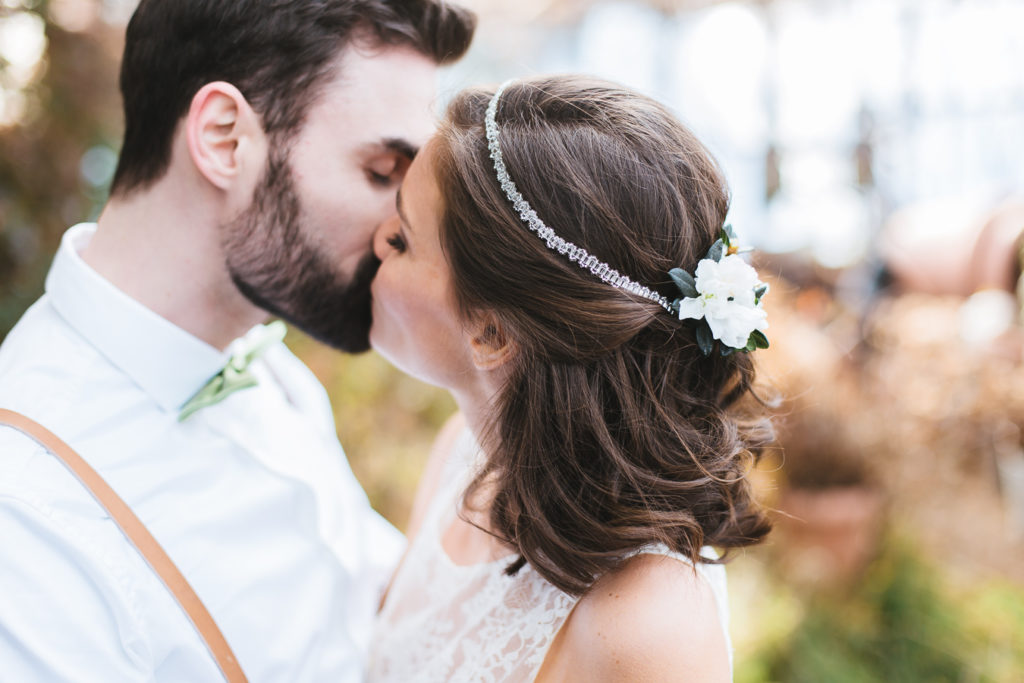 Brautpaar küsst sich in der alten Gärtnerei