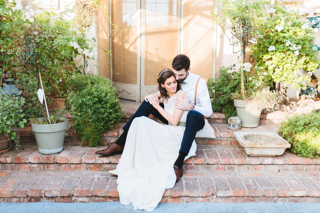 Brautpaar sitzt innig au feiner Treppenstufe