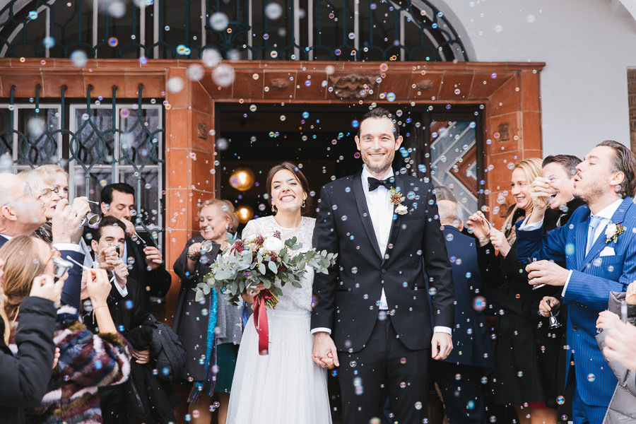 Winterhochzeit mit Brautpaar und Seifenblasen nach ihrer Trauung