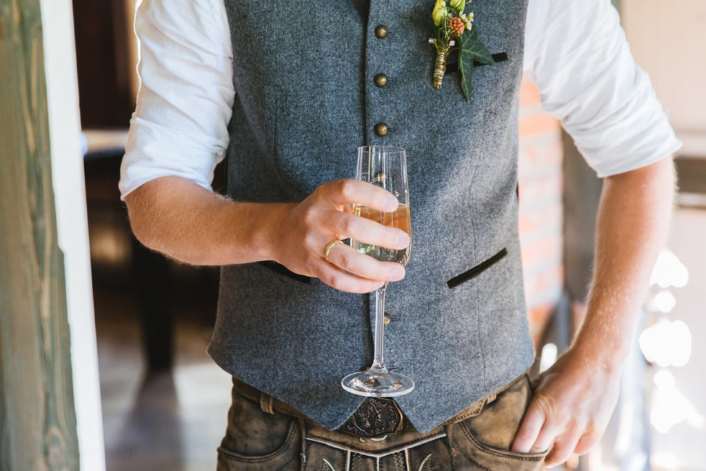 Bräutigam hält Sektglas in der Hand direkt nach der Trauung