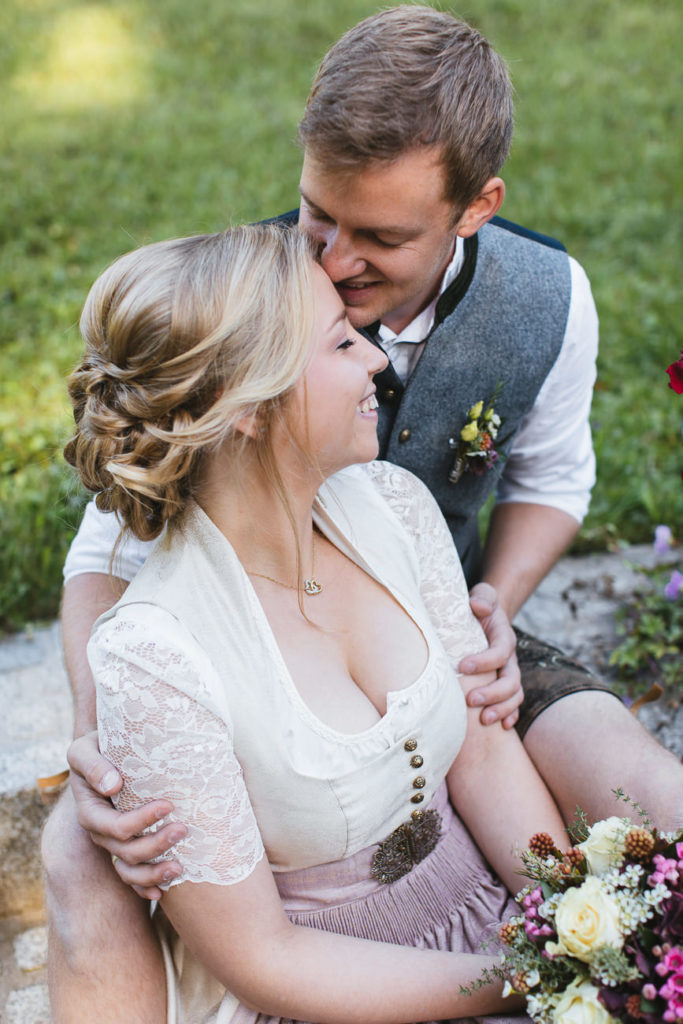 Brautpaarfoto mit lachendem Brautpaar, sitzend auf einer Steintreppe