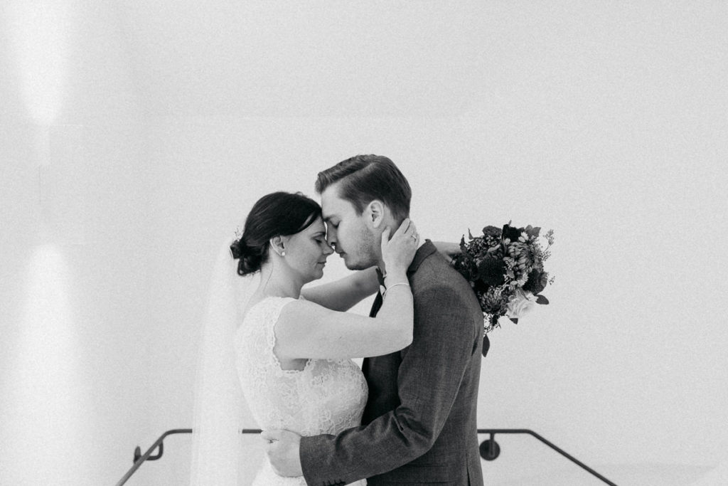 Inniges Brautpaarfoto im Treppenhaus der Menterschwaige