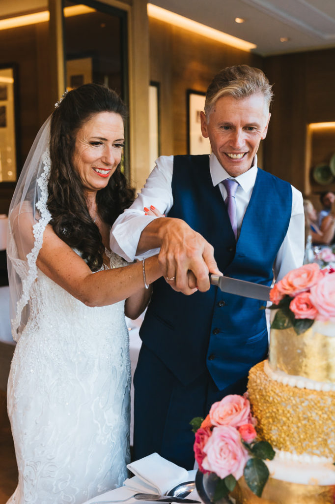 Brautpaar schneidet im Hotel Überfahrt die Torte an