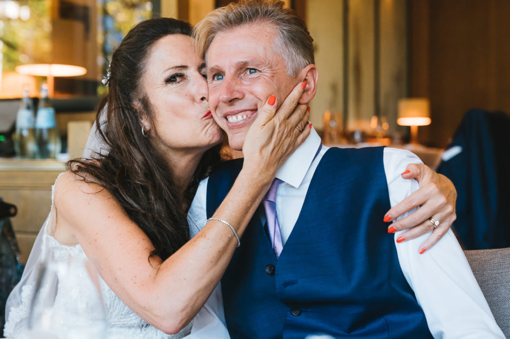 Braut küsst Bräutigam auf die Backe